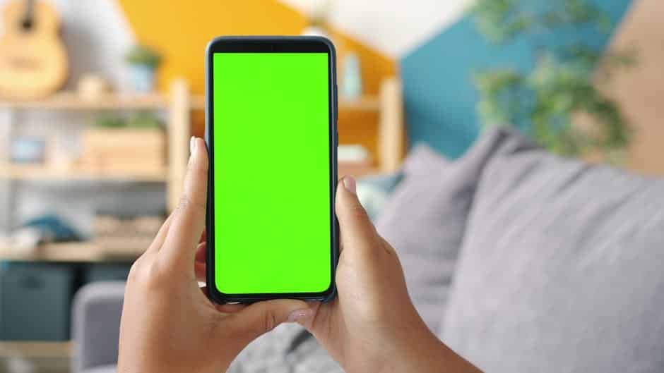 Gros plan sur un particulier utilisant une application mobile de gestion de vidéosurveillance et d’alarme à la maison, démontrant l’intégration des équipements connectés.