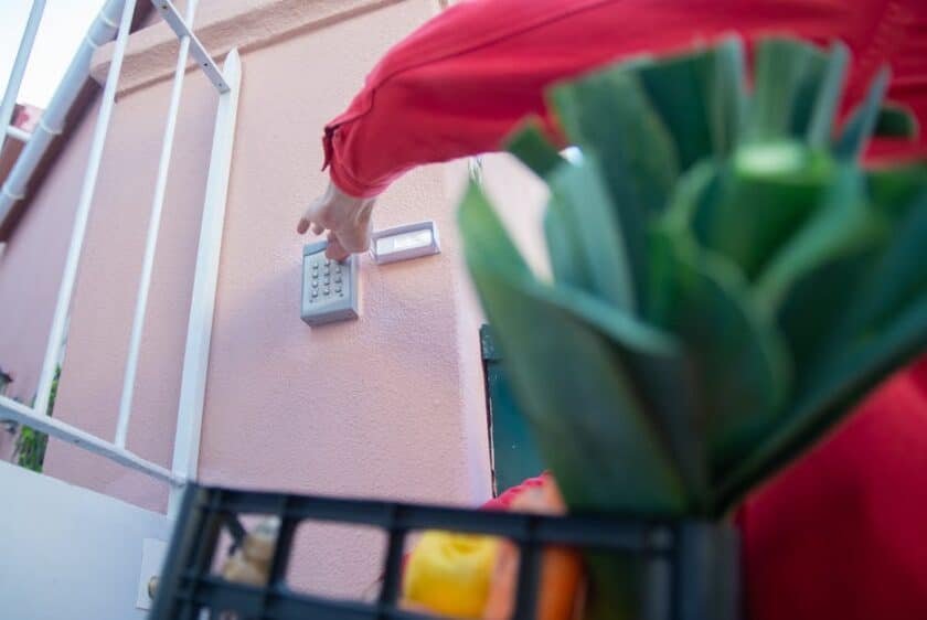 Maison individuelle moderne en France avec volets fermés, lumières allumées en soirée et système d’alarme visible, illustrant une habitation sécurisée pendant les vacances