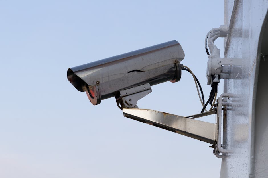 Particulier installant une caméra de surveillance extérieure sur la façade d’une maison en France, étape d’installation pratique et sécurisée