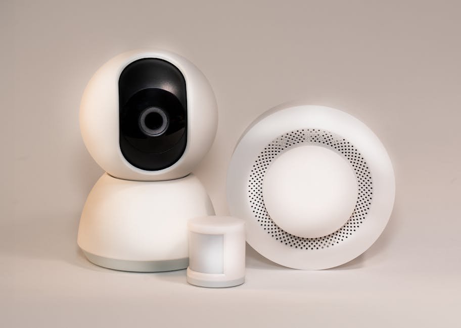 Gros plan sur un détecteur de mouvement connecté sans fil fixé sur un mur intérieur, montrant la technologie utilisée pour la sécurité de la maison