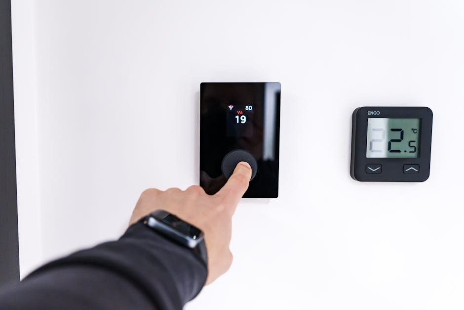 Gros plan sur une main réglant la sensibilité d’une centrale d’alarme dans une maison moderne en France