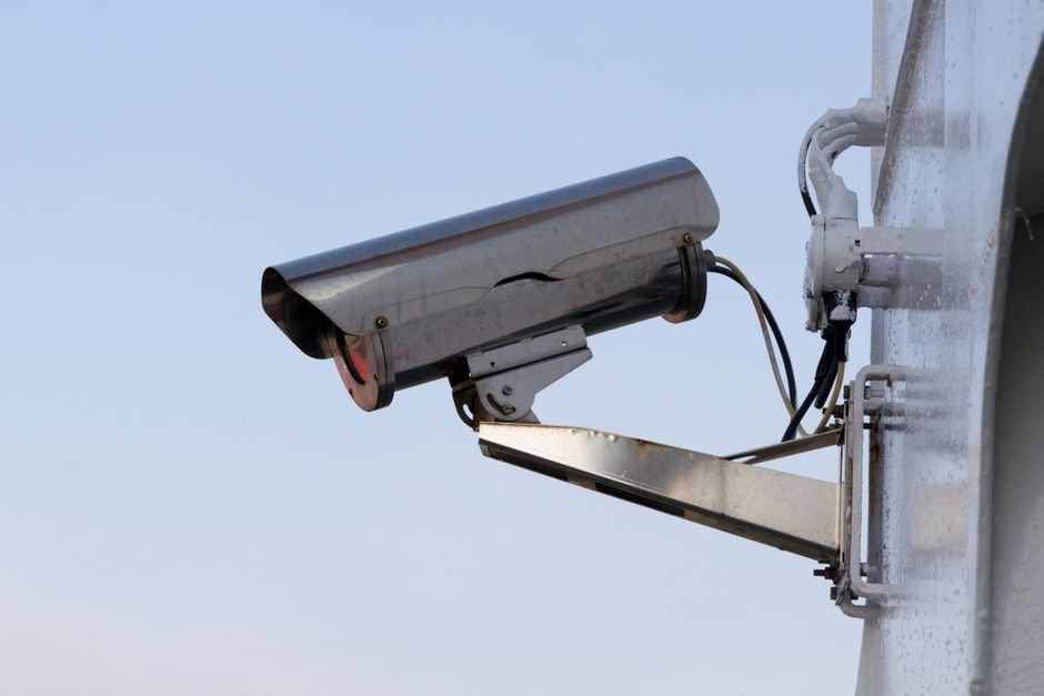 Gros plan sur une caméra de surveillance extérieure bien positionnée sur une maison française, ne filmant que l’entrée privée et respectant la vie privée du voisinage