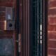 Caméra de vidéosurveillance installée au-dessus de l’entrée d’une maison moderne en France, orientée vers la porte sans filmer la voie publique ni la propriété voisine