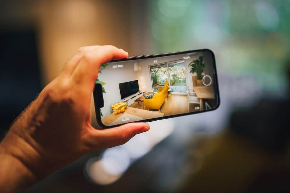 Particulier consultant les images de sa caméra de surveillance sur une application mobile dans un salon moderne en France, illustrant la simplicité d’utilisation du cloud