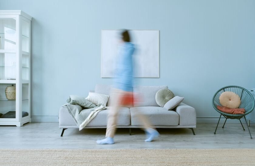 Détecteur de mouvement installé dans un salon moderne de maison française, positionné de façon optimale pour la sécurité sans fausses alertes