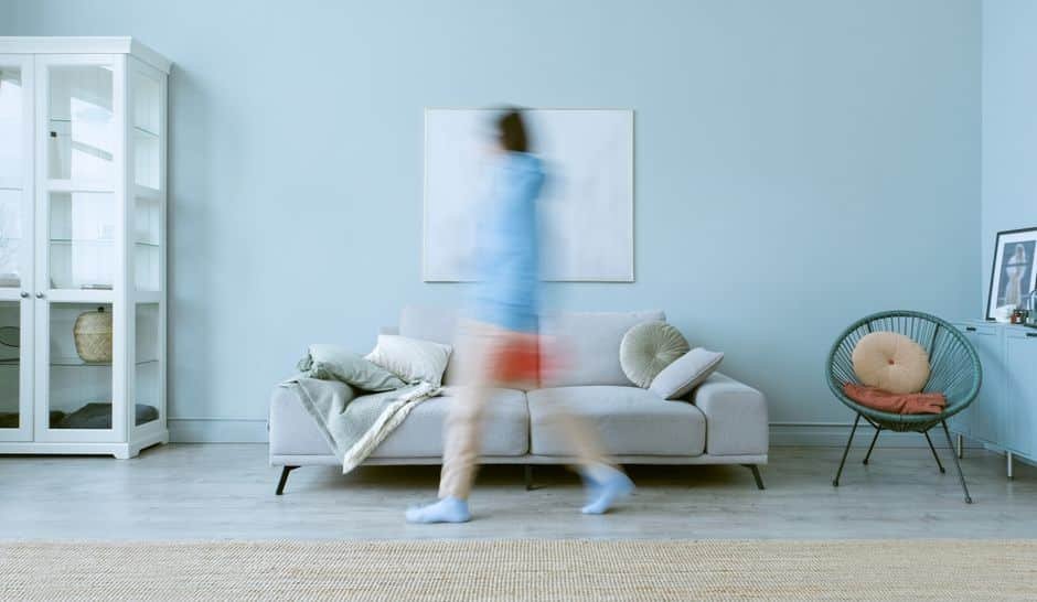 Détecteur de mouvement installé dans un salon moderne de maison française, positionné de façon optimale pour la sécurité sans fausses alertes