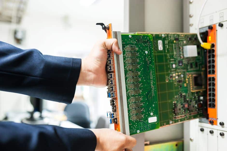 Technicien installant un routeur et un module GSM pour une alarme maison dans une maison individuelle française, montrant la double connexion pour une sécurité fiable