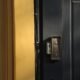Vue réaliste d’un couloir d’immeuble résidentiel en France avec une porte palière sécurisée et un interphone visible, illustrant la sécurité des accès en appartement.