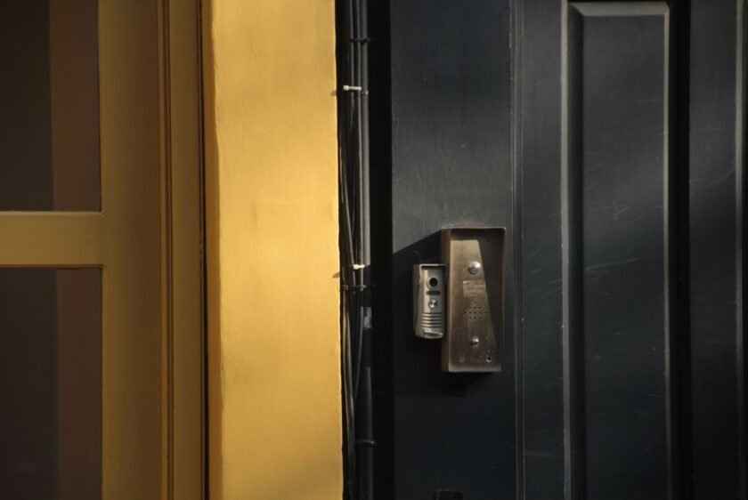 Vue réaliste d’un couloir d’immeuble résidentiel en France avec une porte palière sécurisée et un interphone visible, illustrant la sécurité des accès en appartement.
