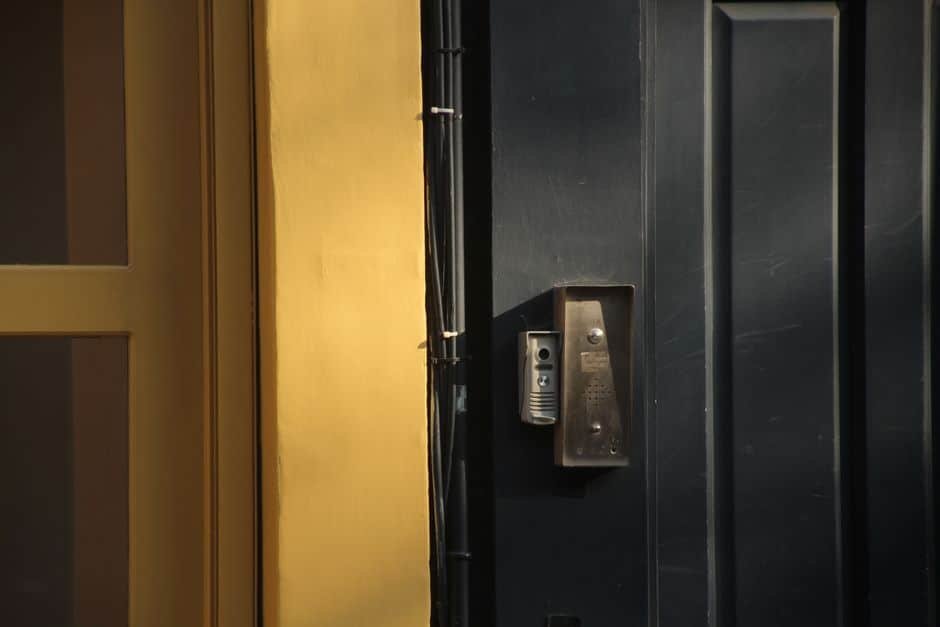 Vue réaliste d’un couloir d’immeuble résidentiel en France avec une porte palière sécurisée et un interphone visible, illustrant la sécurité des accès en appartement.