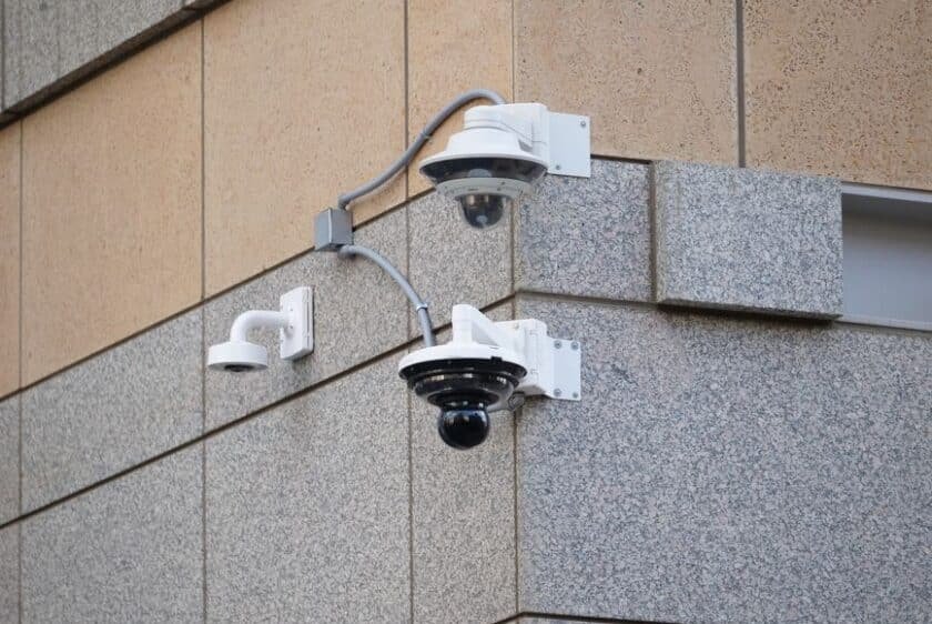 Maison moderne en France équipée de caméras de surveillance et d’une alarme connectée, illustrant la sécurité domestique contre les cyberattaques