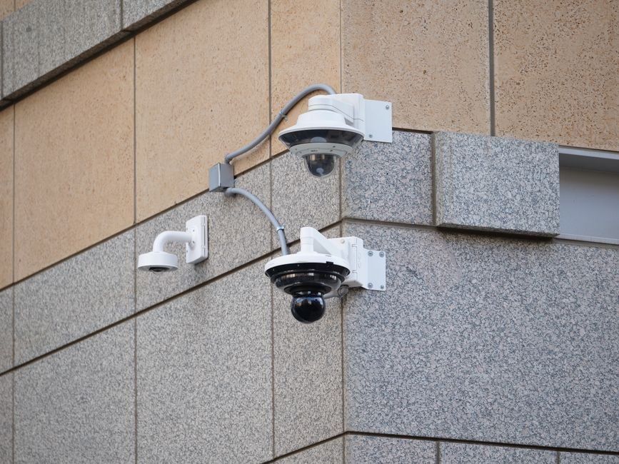Maison moderne en France équipée de caméras de surveillance et d’une alarme connectée, illustrant la sécurité domestique contre les cyberattaques