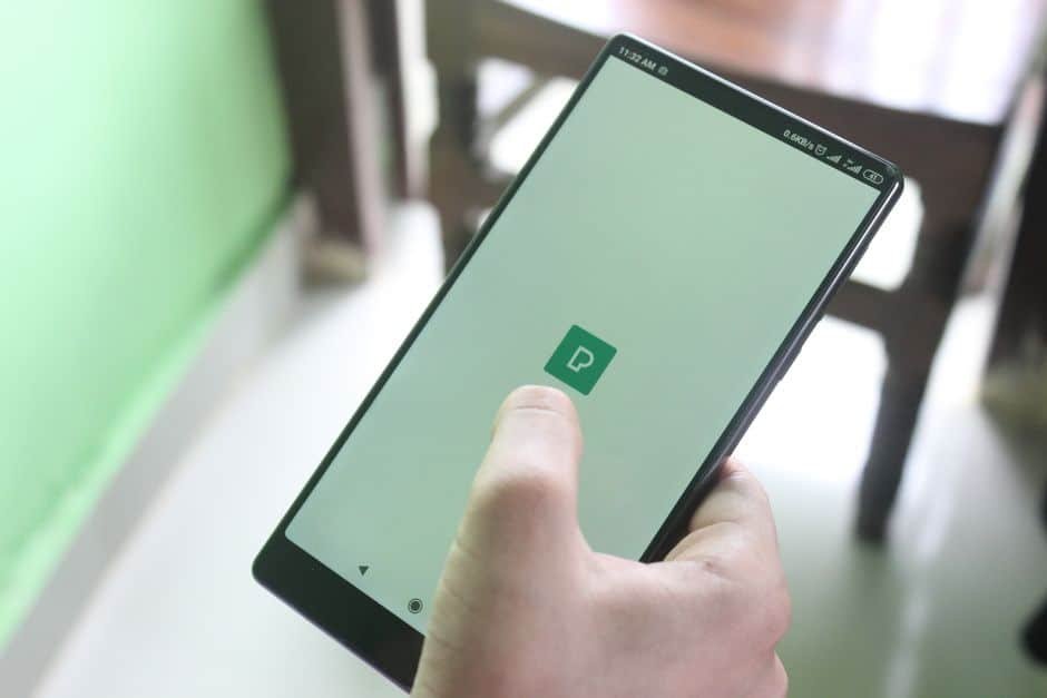Gros plan sur une personne configurant les paramètres de confidentialité d’une caméra intérieure via une application sur tablette dans une maison française
