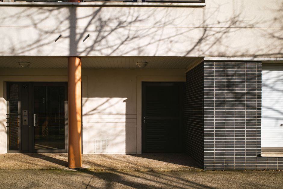 Entrée d’un immeuble résidentiel moderne en France, illustrant les accès à sécuriser pour une alarme appartement efficace