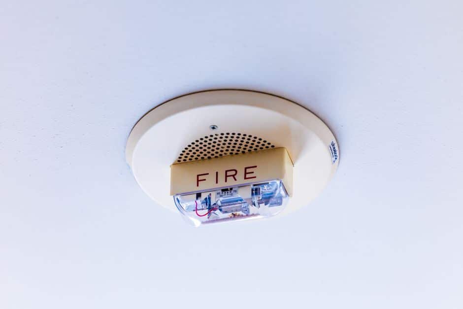Vue intérieure d’une maison française moderne avec différents détecteurs d’alarme installés (détecteur d’ouverture sur porte et fenêtre, détecteur de mouvement dans le couloir), illustrant la protection pièce par pièce.