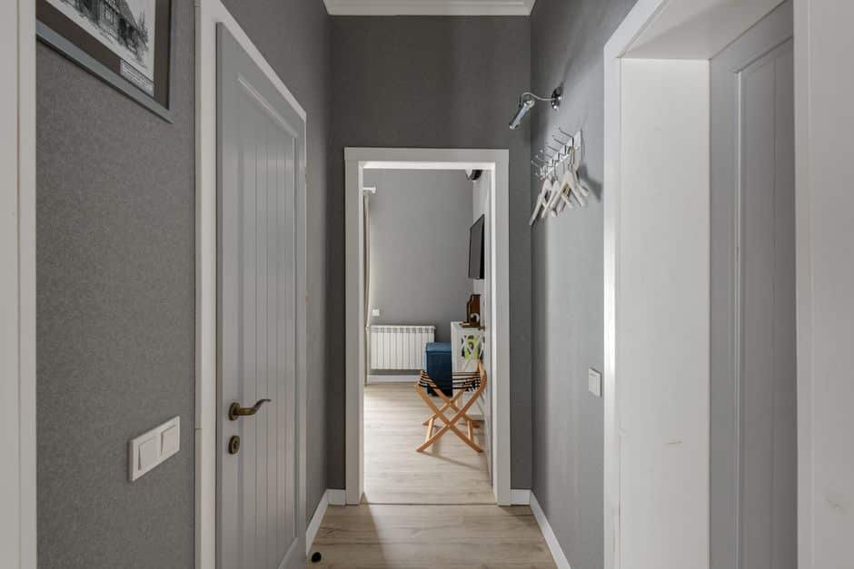 Salon et couloir d’une maison familiale en France avec détecteurs d’alarme visibles, montrant le placement optimal des capteurs de mouvement et d’ouverture pour sécuriser les pièces de vie.
